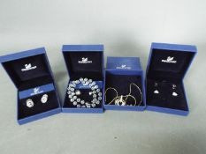 Swarovski - Four boxed Swarovski jewellery items comprising earrings and necklaces.