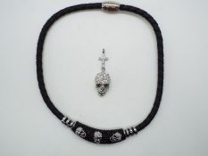 A black necklace with stone set skulls presumed Butler and Wilson and a stone set pendant in the