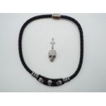 A black necklace with stone set skulls presumed Butler and Wilson and a stone set pendant in the