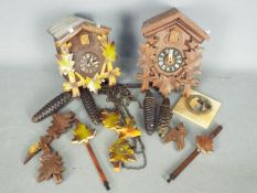 Two German cuckoo clocks with weights and pendulums.