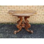 A demilune, fold over card table on highly carved, castored, base,