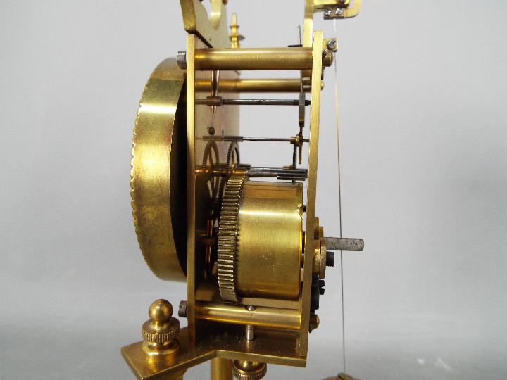 A brass torsion clock with disc pendulum, under glass dome, approximately 31 cm (h). - Image 4 of 6