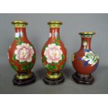 A pair of Chinese cloisonné vases decorated with flowers and birds and one similar,