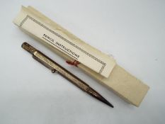 A hallmarked silver propelling pencil with engine turned decoration,