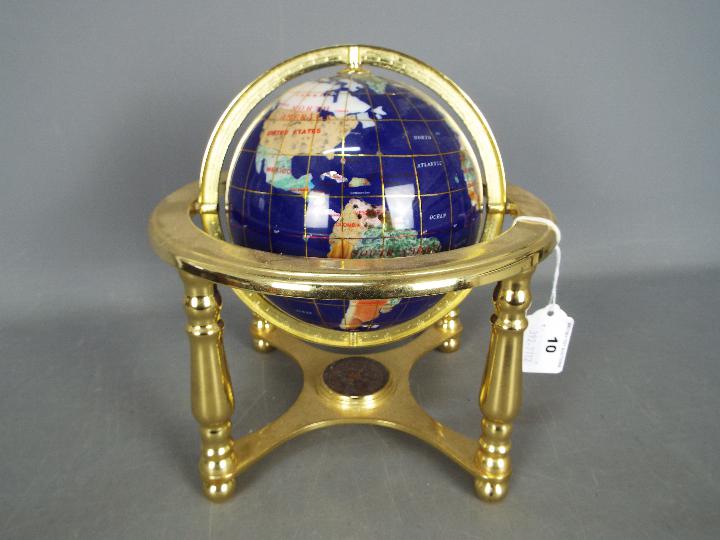 A gemstone terrestrial globe on brass stand, approximately 24 cm (h).