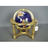 A gemstone terrestrial globe on brass stand, approximately 24 cm (h).