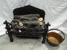 An electric log effect fire and a brass jam pan.