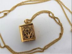 A 9ct gold chain with yellow metal (presumed 14ct gold) Koran / Quran pendant containing miniature