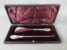 A boxed silver handled shoe horn and button hook