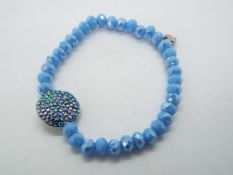 A faceted beaded bracelet with stone set circular pendant design with Wilson and Butler logo