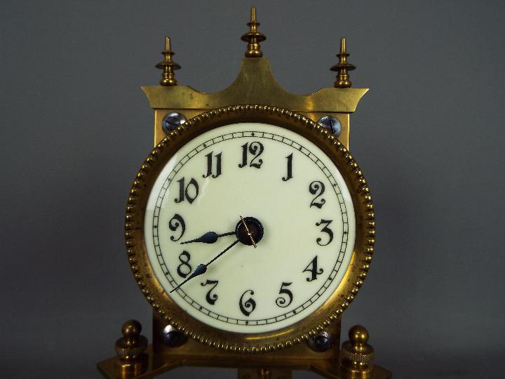 A brass torsion clock with disc pendulum, under glass dome, approximately 31 cm (h). - Image 2 of 6
