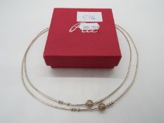 A silver necklace contained in a red box,