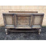 A large highly carved sideboard having t