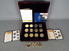 A case containing twelve gold plated com