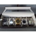 A watch display box containing five wris