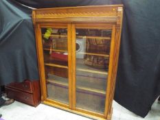 A good quality bookcase with twin glazed doors and carved detailing,