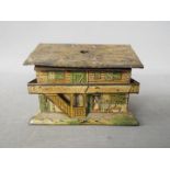 A tin litho money bank in the form of a Swiss cottage,