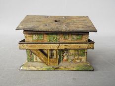 A tin litho money bank in the form of a Swiss cottage,