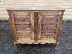 An oak twin door cupboard with faux drawers to the doors, approximately 91 cm x 100 cm x 50 cm.