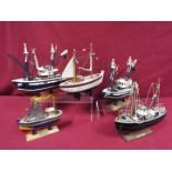 A flotilla of five static wooden models on stands depicting fishing vessels.