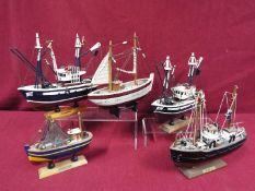 A flotilla of five static wooden models on stands depicting fishing vessels.