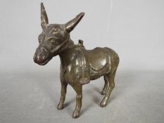 A vintage, cast iron, money bank in the form of a donkey, approximately 12 cm (h).