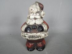 A vintage, cast iron money bank depicting Father Christmas / Santa Claus,