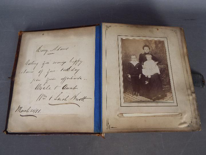 A Victorian, leather bound photograph album with metal clasp, containing photographs.