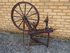 A vintage spinning wheel measuring approximately 100 cm x 102 cm x 47 cm.