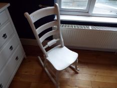 A white painted rocking chair.