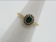 A 9ct gold emerald and diamond cluster ring, size N, approximately 2.4 grams all in.