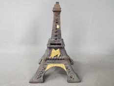 A cast metal money bank in the form of the Eiffel Tower,