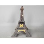 A cast metal money bank in the form of the Eiffel Tower,