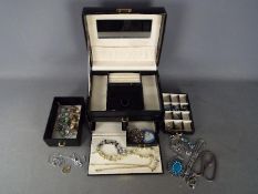 A good quality jewellery box containing a collection of costume jewellery to include a large