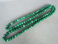 A large single strand necklace of polished malachite beads, each bead approximately 1.