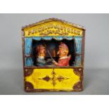 A cast iron mechanical money bank in the form of Mr Punch and Judy, approximately 18 cm (h).