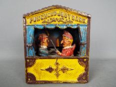 A cast iron mechanical money bank in the form of Mr Punch and Judy, approximately 18 cm (h).