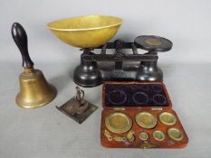 A set of kitchen scales, wood cased set of Avery weights and a small hand bell.