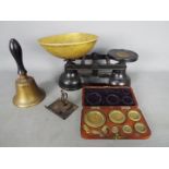 A set of kitchen scales, wood cased set of Avery weights and a small hand bell.