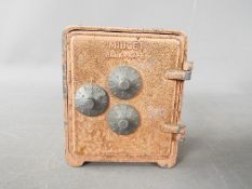 A vintage cast aluminium money bank in the form of a safe,