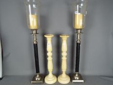 Two pairs of floor standing candle stands / holders, one pair by Laura Ashley,