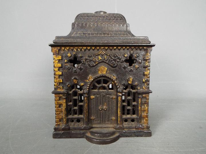 A Victorian cast iron money bank of architectural form, depicting a bank, approximately 12.