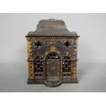 A Victorian cast iron money bank of architectural form, depicting a bank, approximately 12.