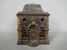 A Victorian cast iron money bank of architectural form, depicting a bank, approximately 12.