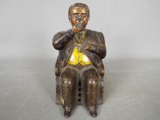 A late 19th century cast iron money bank in the form of William Magear Tweed, seated in a chair,