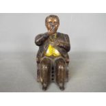 A late 19th century cast iron money bank in the form of William Magear Tweed, seated in a chair,