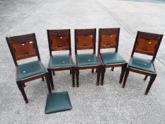 Five dining chairs with carved detailing.