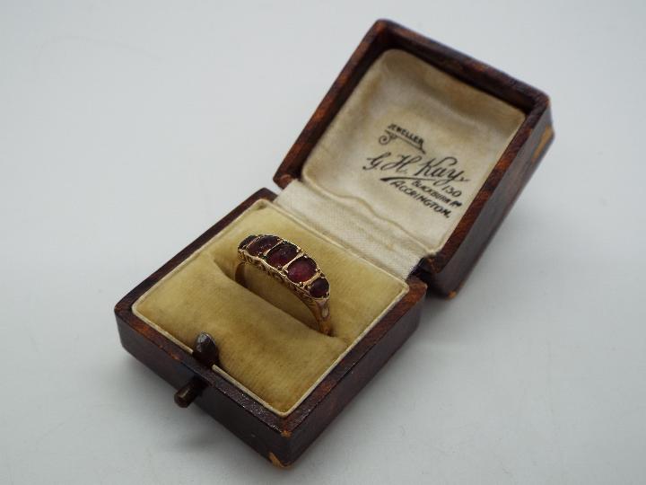 A 9ct gold and garnet ring, size O + ½, approximately 1.9 grams all in. - Image 6 of 6