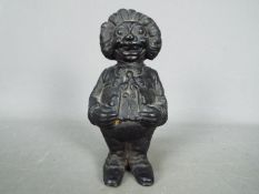 A cast iron, novelty money bank in the form of a standing Golly,