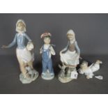 Lladro - Two Lladro figurines including a girl with a rabbit and a boy in dungarees,